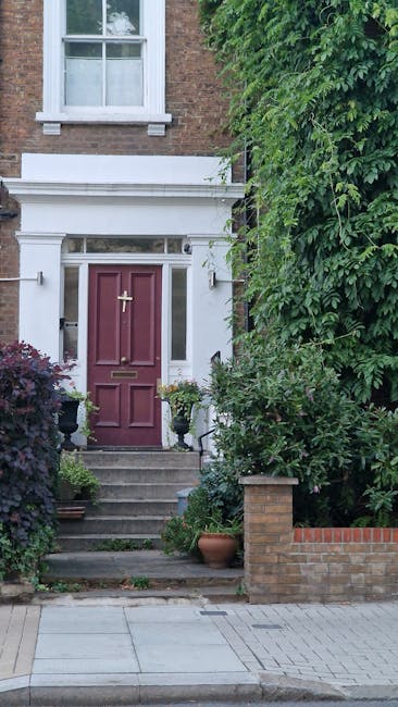 A well-maintained front garden featuring neatly trimmed hedges along the border, with a lush green lawn area showing fresh mowing lines. In the foreground, there are gardening tools such as shears and
